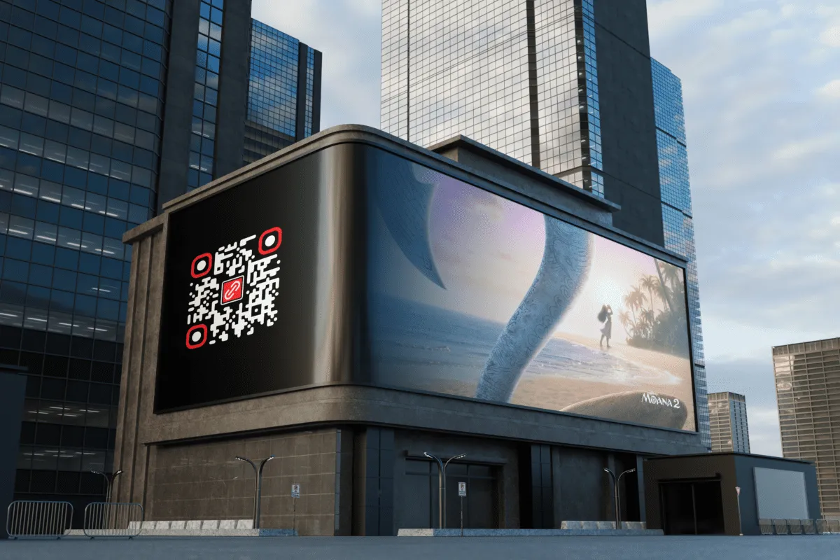 Mockup of a curved-corner digital LED billboard in a modern urban area with skyscrapers. The screen shows a large QR code on the left with the 'LINK' logo, and a poster for the Disney movie 'Moana 2' on the right with a magical fishhook. It illustrates the strategic use of QR codes in out-of-home advertising (billboards) for Black Friday campaigns, letting passersby scan for exclusive offers. The setting highlights how digital technology integrates with traditional advertising at a busy urban intersection.