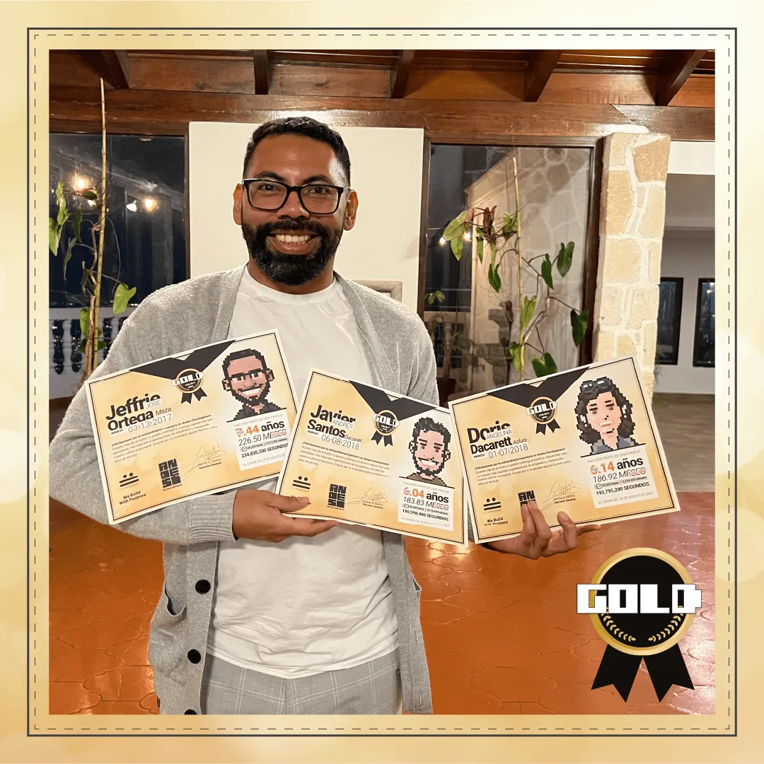 Andes Development team member proudly posing with three Gold Award diplomas, which recognize the team members (Jeffrie Ortega, Javier Santos, and Doris Dacarett) with more than 5 years of tenure and loyalty at the agency during the 12th anniversary event.