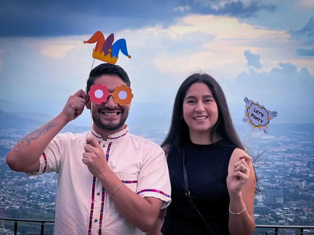Colaboradores de Andes Development disfrutando de la fiesta de 12º aniversario con divertidos accesorios para fotos. La imagen refleja el ambiente ameno, la integración y la fuerte cultura laboral de la agencia.