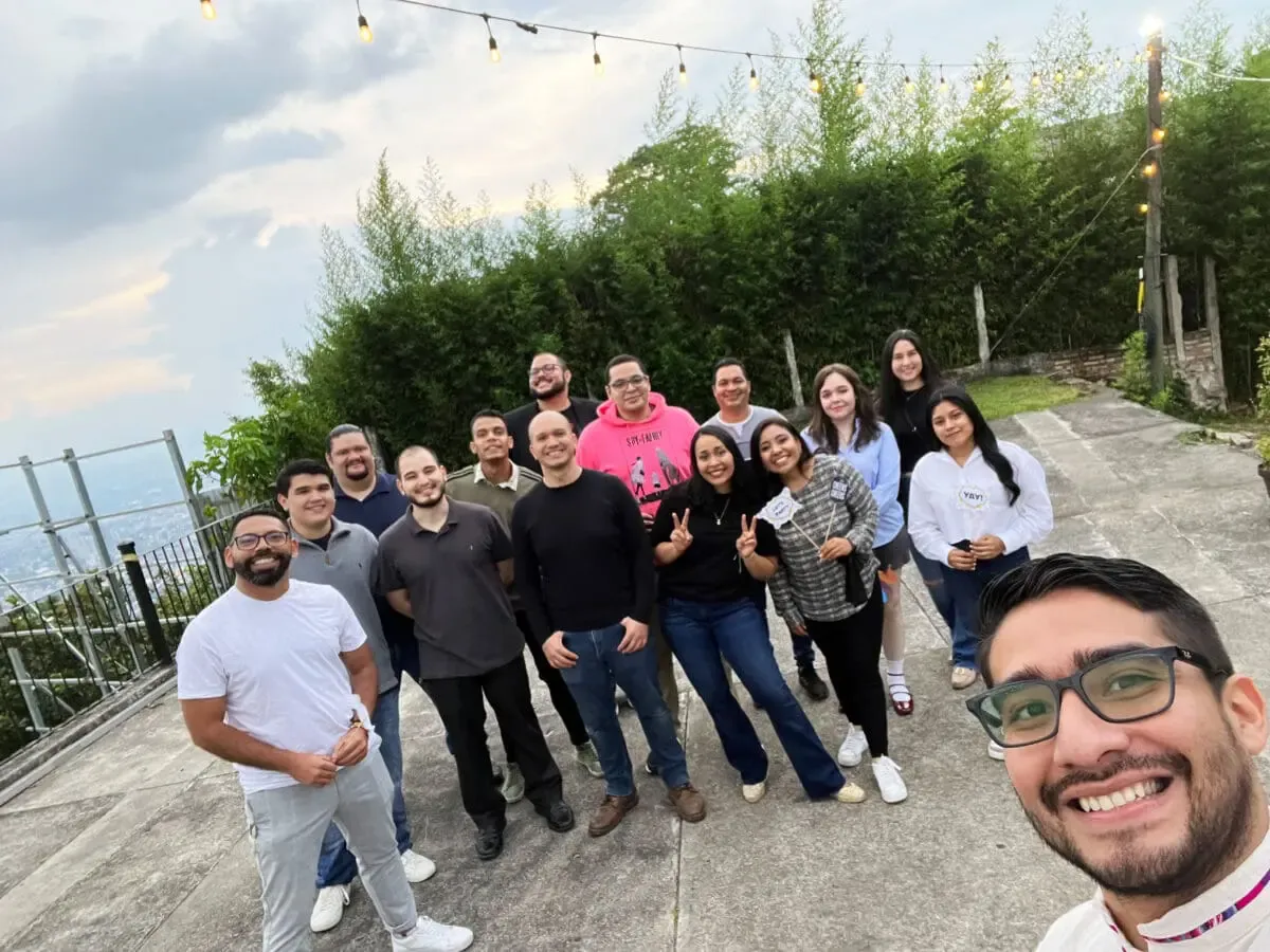 Selfie grupal del equipo de Andes Development sonriendo durante la celebración de su 12º aniversario. La fotografía al aire libre captura la sólida cultura corporativa, el compañerismo y la unión de la agencia tecnológica.