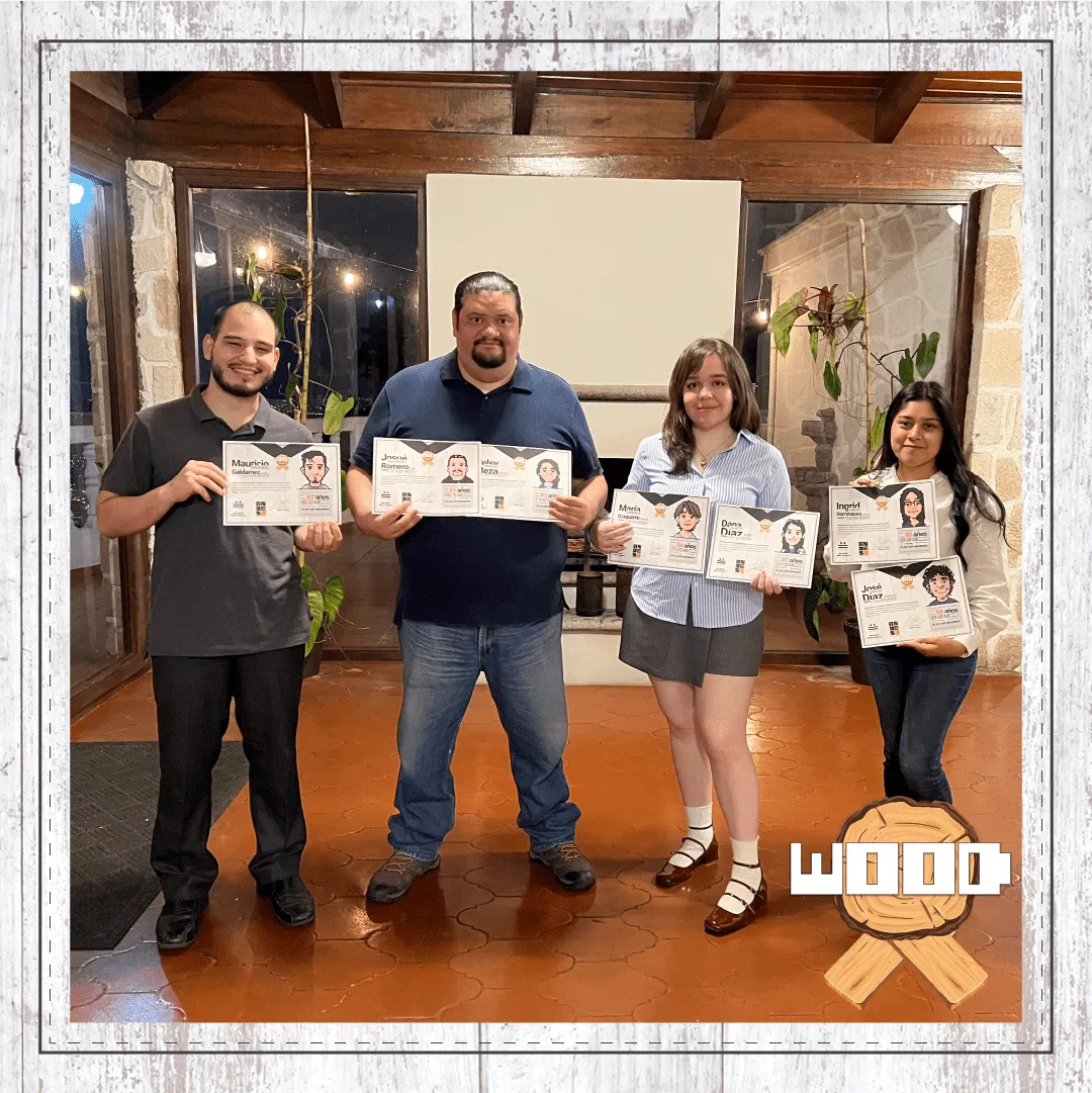 Fotografía grupal de varios miembros del equipo de Andes Development sosteniendo orgullosamente sus diplomas del Premio Wood. Celebra la fidelidad de 2 a 3 años en la empresa durante la convivencia del 12º aniversario corporativo.